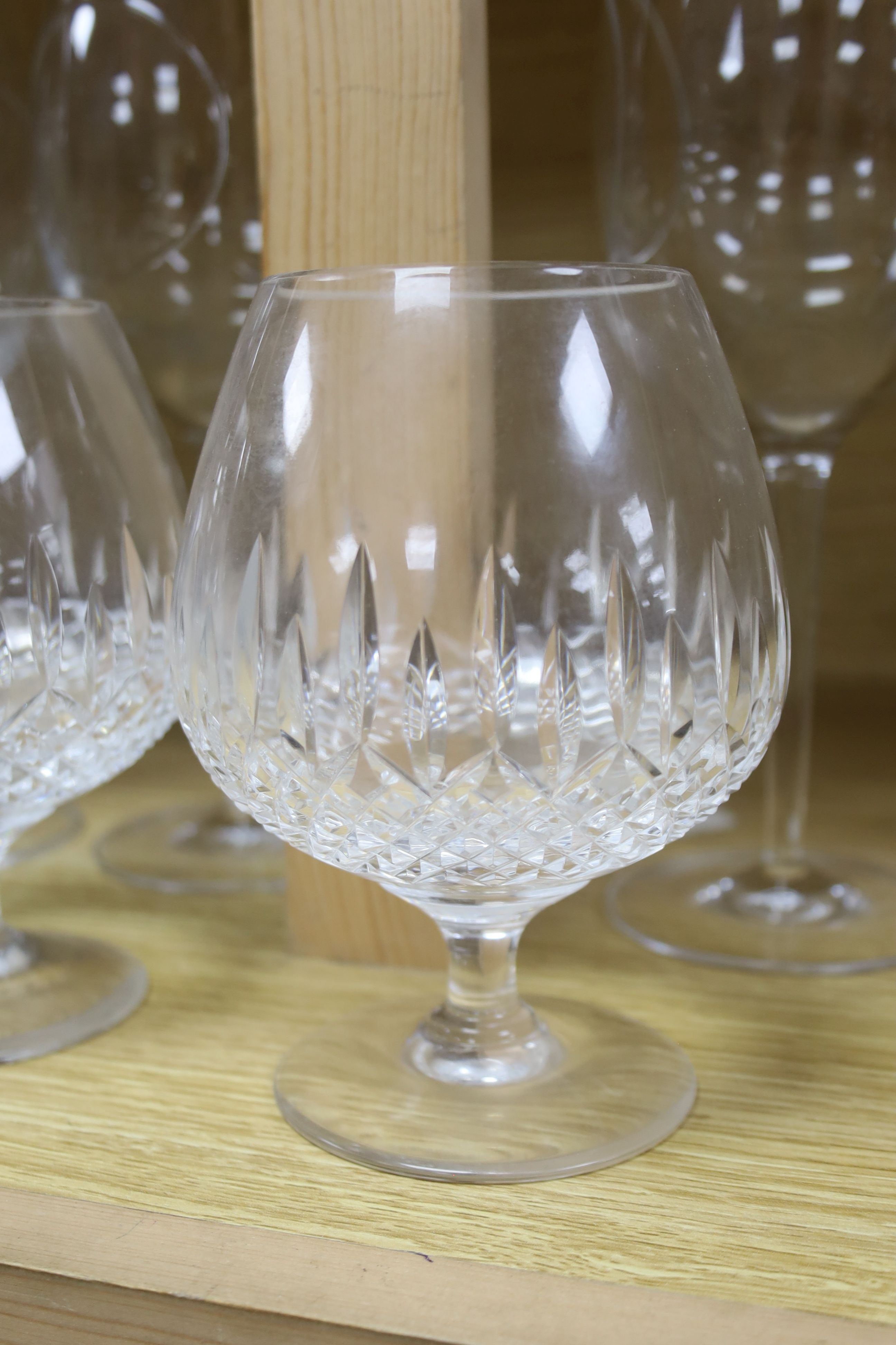 Four John Rocha Waterford wine glasses and three Stuart cut glass brandy glasses